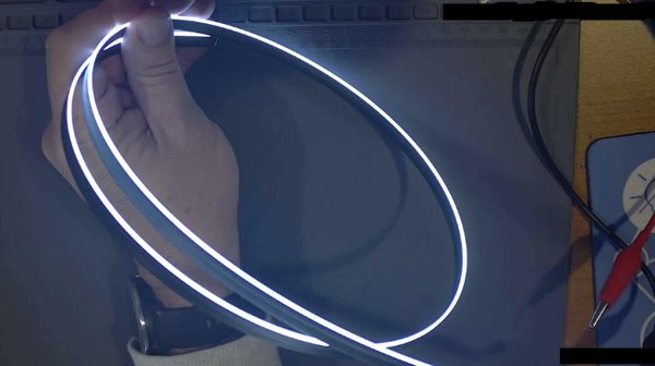 Ultra-thin white edge-lit strip, hand-held for scale